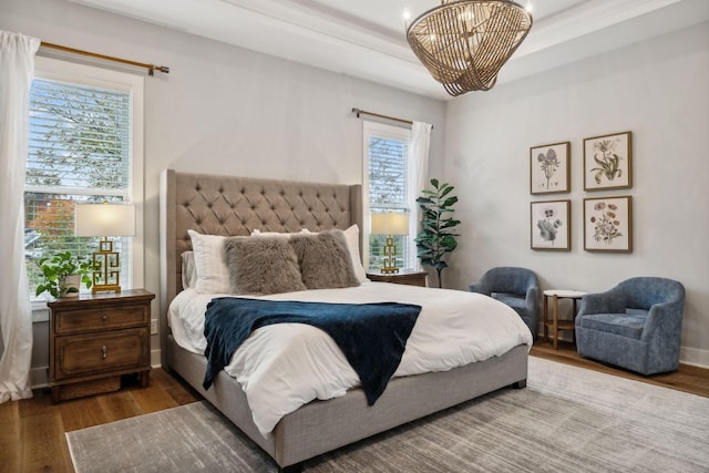 bedroom featuring a chandelier, wood-type flooring, and multiple windows