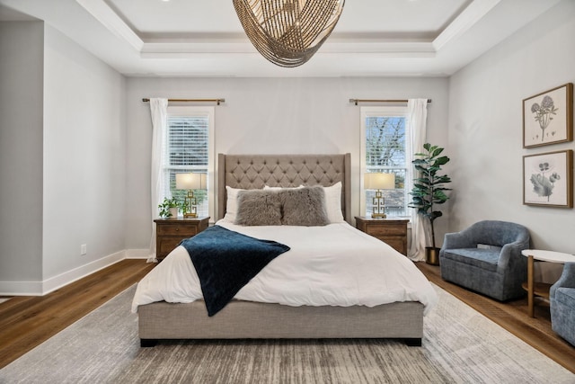 bedroom with hardwood / wood-style flooring and a raised ceiling