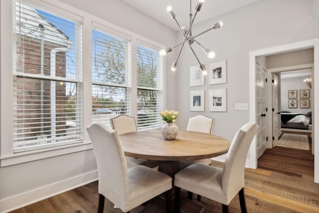 dining space featuring hardwood / wood-style flooring and an inviting chandelier