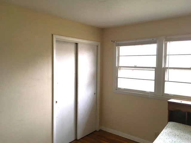 unfurnished bedroom featuring dark hardwood / wood-style floors and a closet