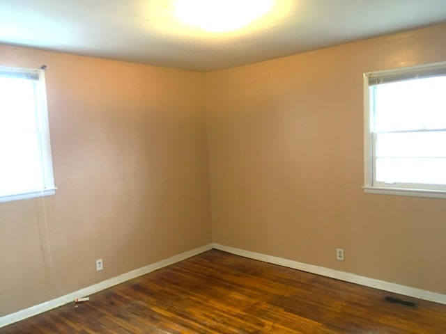 unfurnished room with dark hardwood / wood-style flooring