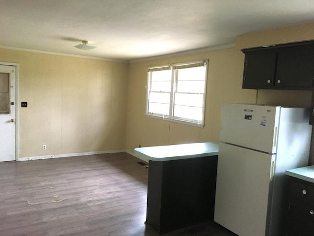 kitchen with kitchen peninsula, white refrigerator, dark hardwood / wood-style floors, and ornamental molding