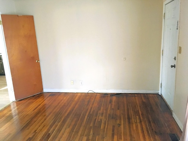 spare room with dark hardwood / wood-style floors