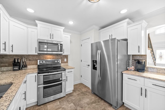 kitchen with white cabinets, appliances with stainless steel finishes, decorative backsplash, and crown molding