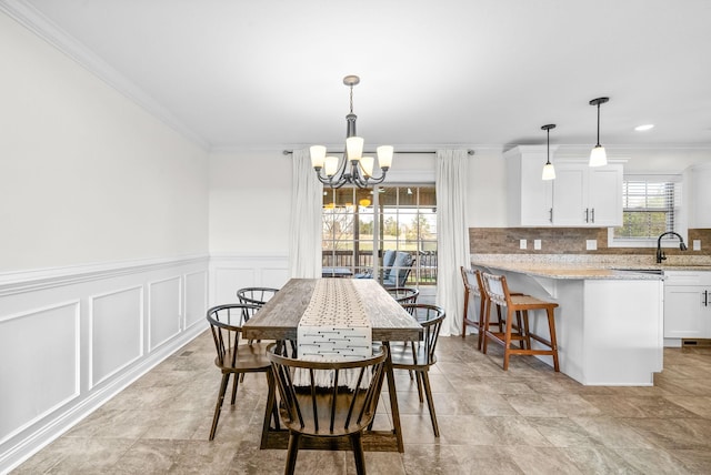 dining area with crown molding and a chandelier