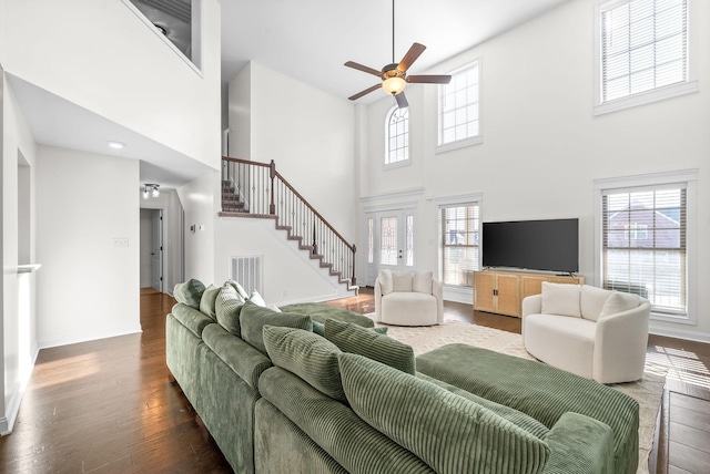 living room featuring a healthy amount of sunlight, wood-type flooring, and a high ceiling