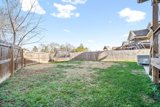 view of yard featuring central AC and a trampoline