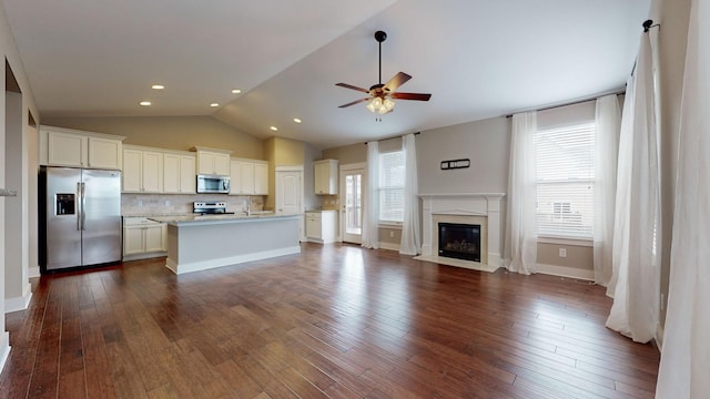 kitchen featuring decorative backsplash, appliances with stainless steel finishes, a center island with sink, and a healthy amount of sunlight