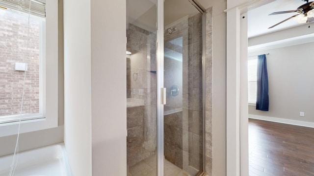 bathroom with ceiling fan, wood-type flooring, and walk in shower