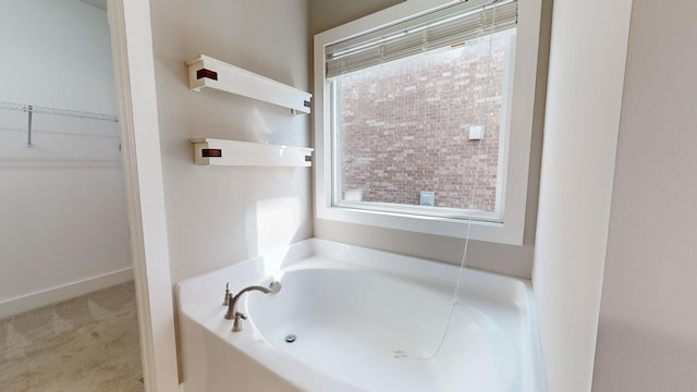 bathroom featuring a bathtub and a wealth of natural light