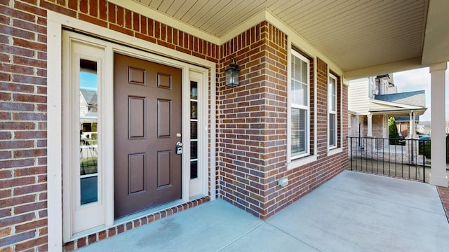 view of exterior entry featuring covered porch