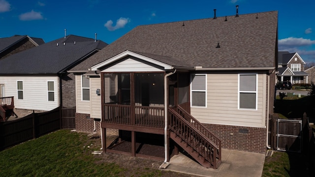 rear view of house featuring a sunroom and a yard