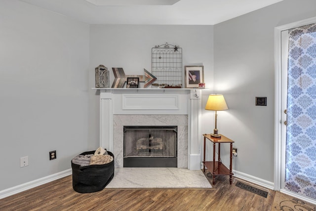 interior space with a high end fireplace and hardwood / wood-style flooring