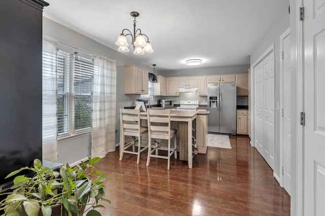 kitchen with stainless steel fridge, a healthy amount of sunlight, hanging light fixtures, and an inviting chandelier