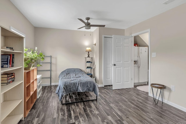 bedroom featuring ceiling fan, white fridge with ice dispenser, and dark wood-type flooring