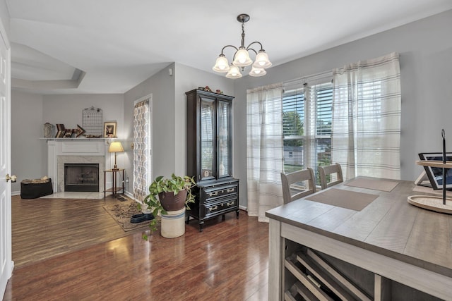 dining space featuring dark hardwood / wood-style floors and an inviting chandelier