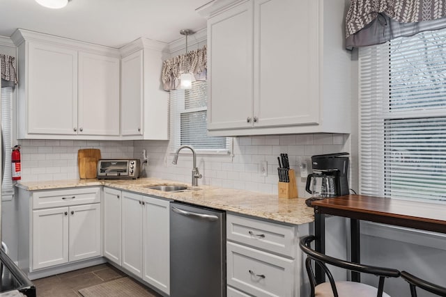 kitchen featuring white cabinets, dishwasher, decorative backsplash, and sink