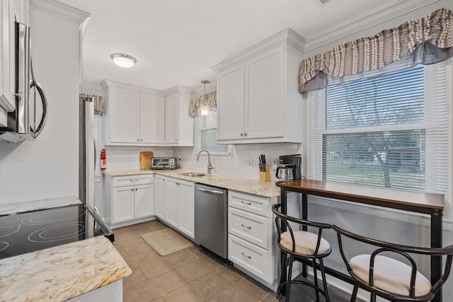 kitchen featuring tasteful backsplash, sink, pendant lighting, dishwasher, and white cabinetry