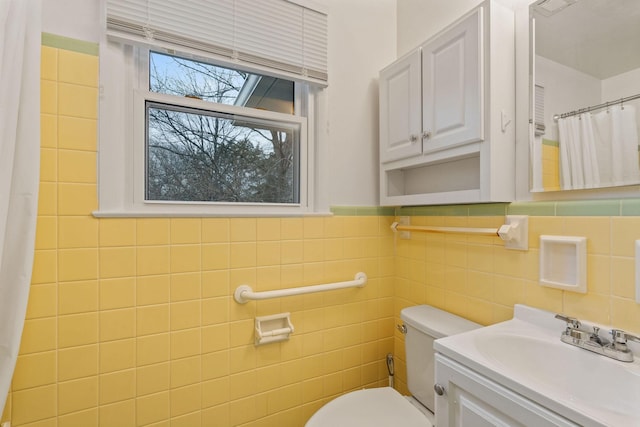 bathroom with walk in shower, vanity, toilet, and tile walls