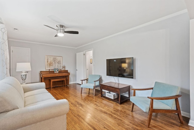 living room with light hardwood / wood-style flooring, ceiling fan, and crown molding