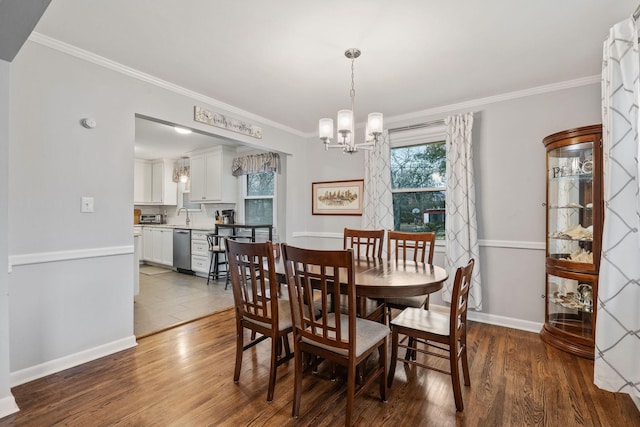 dining area featuring sink, ornamental molding, dark hardwood / wood-style floors, and a notable chandelier