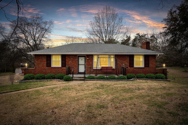 ranch-style home with a yard