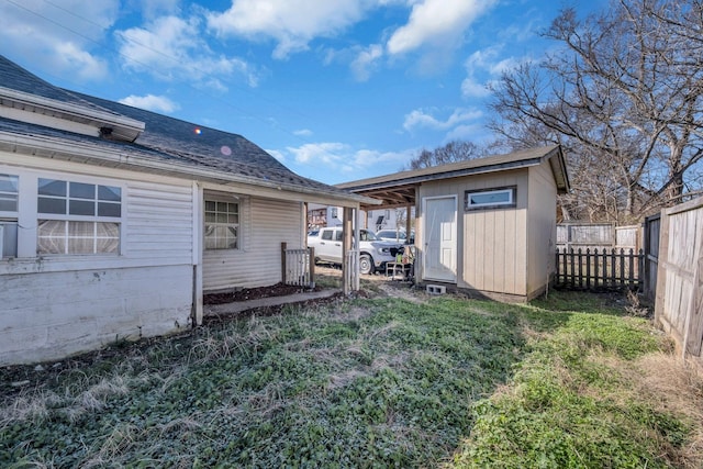 rear view of house featuring a yard and a storage unit