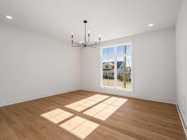 unfurnished dining area with hardwood / wood-style flooring and a chandelier