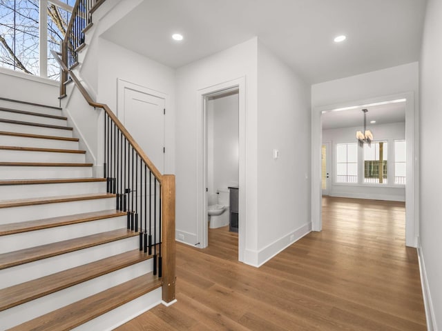 stairs with a notable chandelier and wood-type flooring