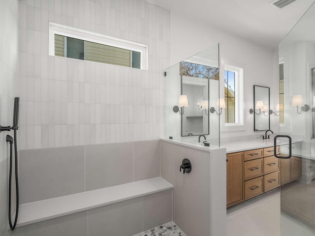 bathroom featuring vanity, a tile shower, and tile patterned floors