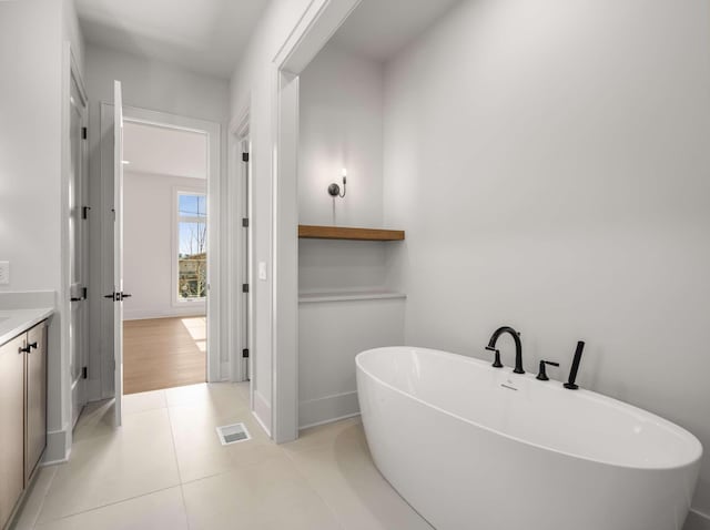 bathroom with vanity, a bathing tub, and tile patterned flooring