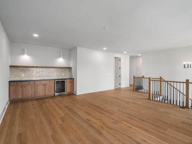 interior space with decorative backsplash, light hardwood / wood-style flooring, and beverage cooler