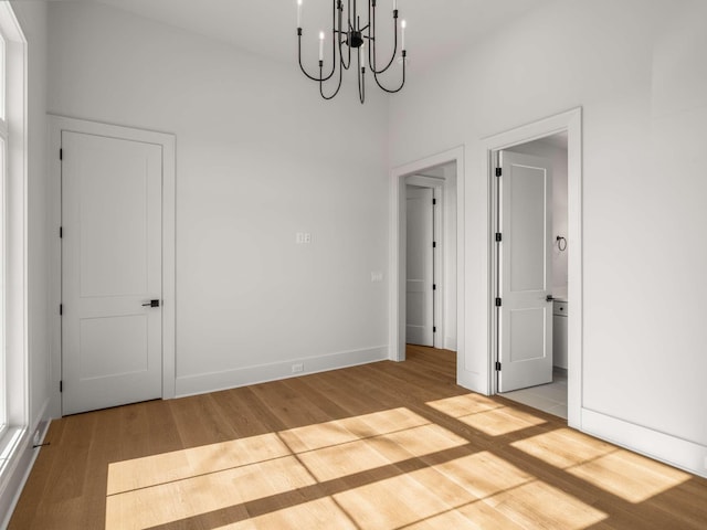 spare room featuring light hardwood / wood-style flooring and a notable chandelier