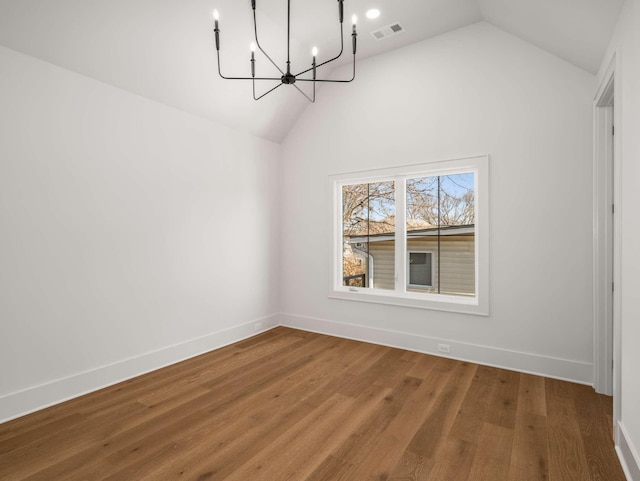 unfurnished dining area with hardwood / wood-style flooring, vaulted ceiling, and a notable chandelier