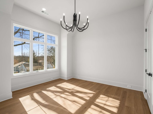 unfurnished dining area featuring dark wood-type flooring and an inviting chandelier