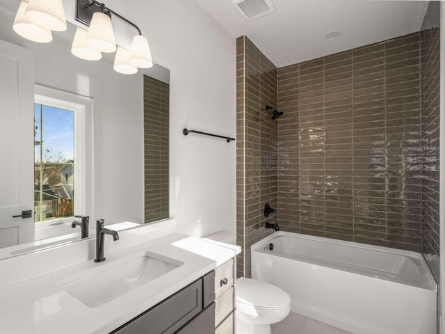 full bathroom with vanity, tiled shower / bath combo, and toilet