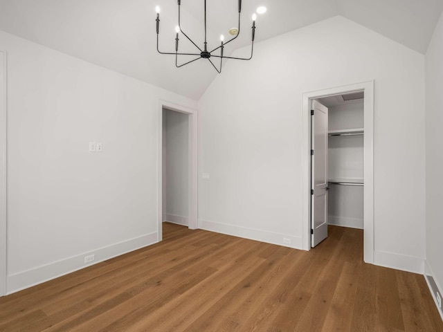 interior space featuring a walk in closet, lofted ceiling, hardwood / wood-style floors, and a closet