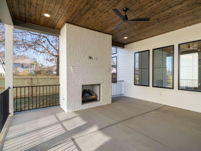 view of patio with ceiling fan and a large fireplace