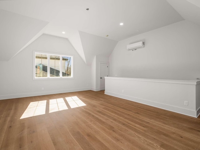 bonus room with lofted ceiling, wood-type flooring, and an AC wall unit