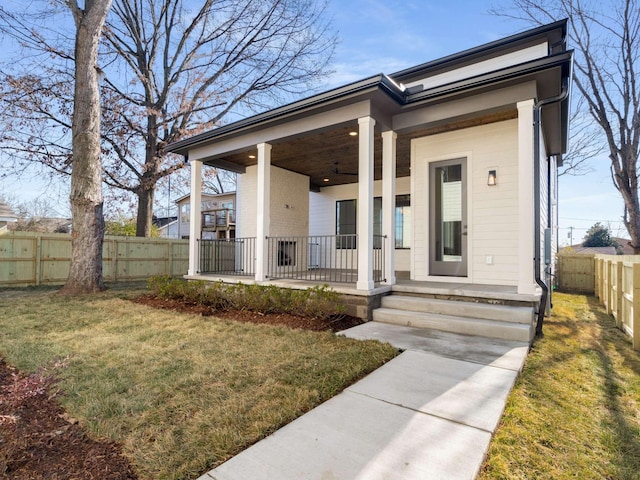 view of front of house featuring covered porch and a front lawn