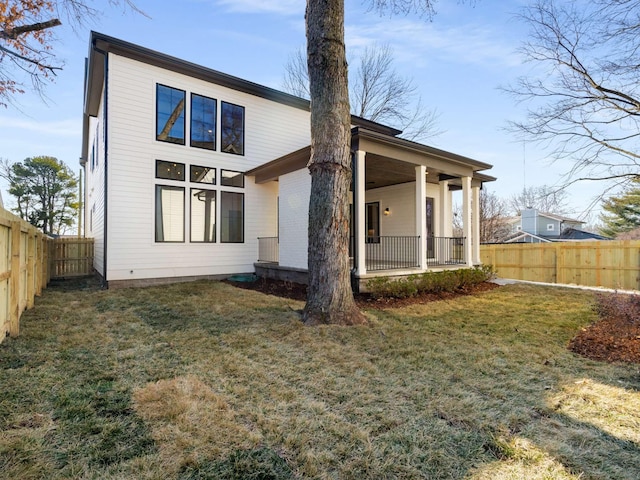 rear view of house featuring a lawn