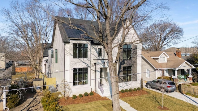 view of front facade with a front yard and central air condition unit