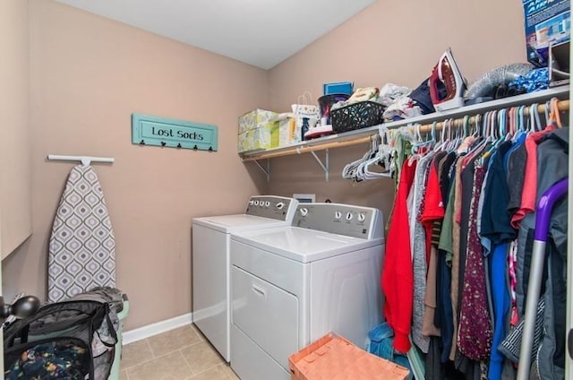 laundry area featuring washing machine and clothes dryer and light tile patterned flooring