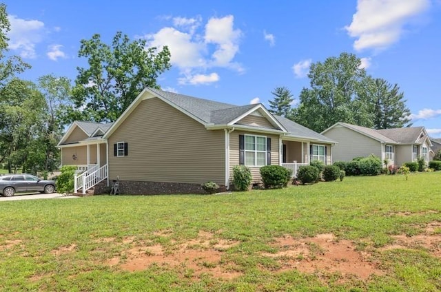 view of side of property featuring a lawn and covered porch