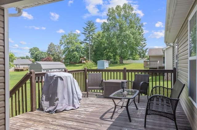 wooden deck featuring a lawn and a storage unit