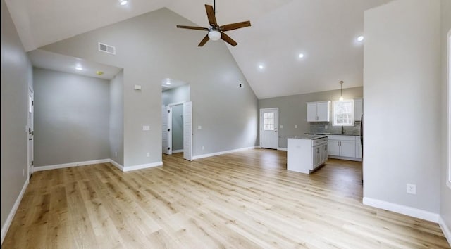 unfurnished living room featuring ceiling fan, sink, high vaulted ceiling, and light hardwood / wood-style floors