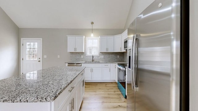 kitchen featuring white cabinetry, a center island, pendant lighting, and appliances with stainless steel finishes