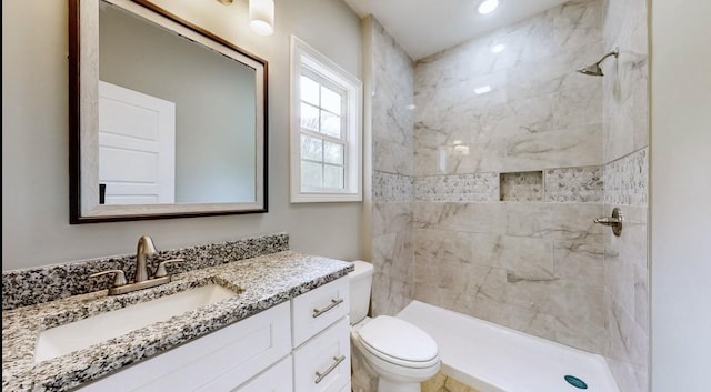 bathroom featuring tiled shower, vanity, and toilet