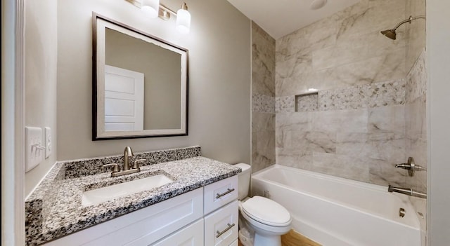 full bathroom with vanity, tiled shower / bath combo, and toilet