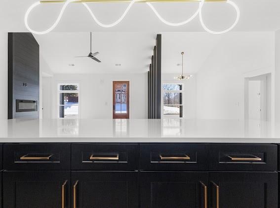 kitchen with lofted ceiling, light countertops, a ceiling fan, and dark cabinets